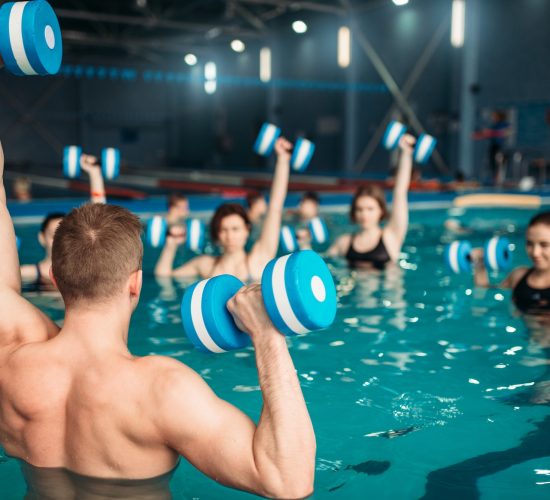 Class with trainer on workout with aqua dumbbells