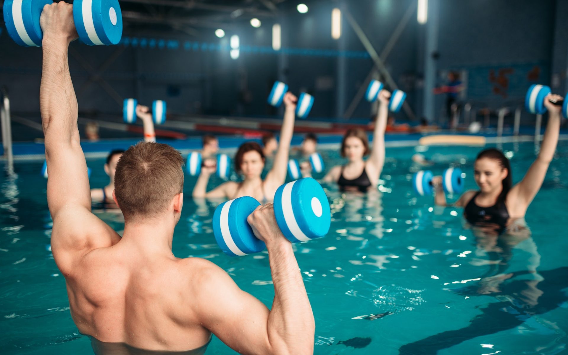 Class with trainer on workout with aqua dumbbells